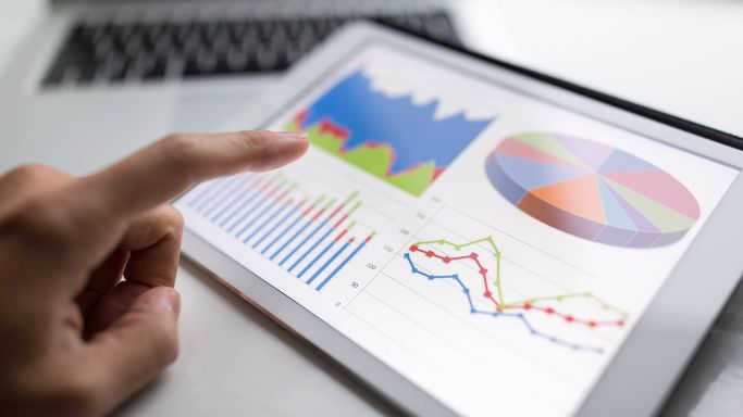 Die Abbildung zeigt eine männliche Hand, die ein Tablet bedient, auf dem Diagramme zu sehen sind (Quelle: Leung Cho Pan/PantherMedia/picture alliance) Die Abbildung zeigt eine männliche Hand, die ein Tablet bedient, auf dem Diagramme zu sehen sind
