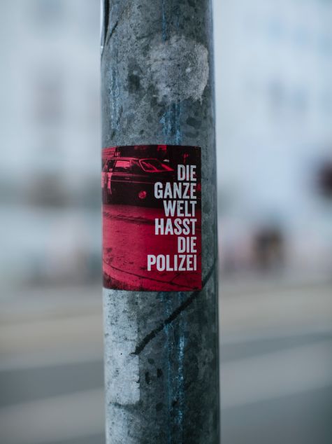 Die Aufnahme zeigt ein Plakat, das auf einen Mast geklebt ist, mit der Aufschrift "Die ganze Welt hasst die Polizei"  (Quelle: Markus Spiske / unsplash.com) Die Aufnahme zeigt ein Plakat, das auf einen Mast geklebt ist, mit der Aufschrift "Die ganze Welt hasst die Polizei"