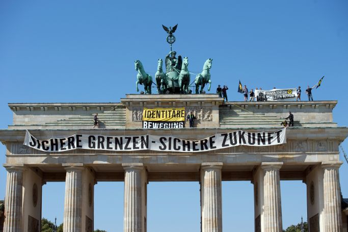 Das Bild zeigt das Brandenburger Tor mit Transparenten und der Aufschrift „sichere Grenzen-sichere Zukunft“ (Quelle: picture alliance / dpa | Paul Zinken) Das Bild zeigt das Brandenburger Tor mit Transparenten und der Aufschrift „sichere Grenzen-sichere Zukunft“