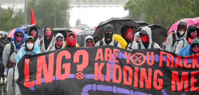 Die Aufnahme zeigt Demonstranten mit einem Transparent "LNG? are you fracking kidding me?" am 31.07.2021 in Brunsbüttel (Quelle: picture alliance / dpa | Jonas Walzberg) Die Aufnahme zeigt Demonstranten mit einem Transparent "LNG? are you fracking kidding me?" am 31.07.2021 in Brunsbüttel