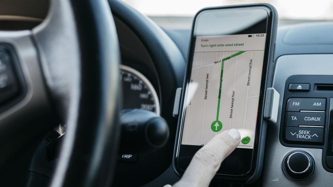 The shot shows a woman at the wheel of a car using a map app on her smartphone to calculate a route (Source: Josep Rovirosa/Westend61/picture alliance) The shot shows a woman at the wheel of a car using a map app on her smartphone to calculate a route
